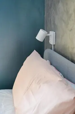 a bed with a white pillow and a lamp at Modern apartment center Palermo in Palermo