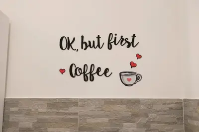a wall with a coffee cup and the words ok but first coffee at Maison Zisa - Proppro SRL - Palermo in Palermo