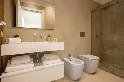 a bathroom with a sink and a toilet and a mirror at Luxury Villa Leto in Palermo