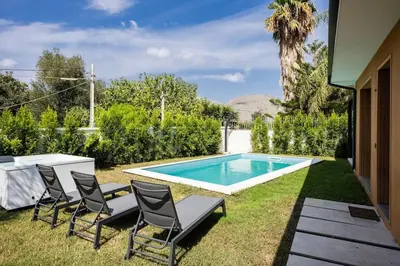 a backyard with a pool with chairs and a table at Luxury Jacuzzi Villa Diana in Palermo