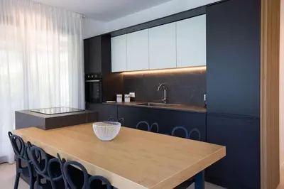 a kitchen with a wooden table and a sink at Luxury Jacuzzi Villa Diana in Palermo
