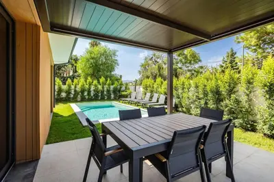 a patio with a table and chairs and a swimming pool at Luxury Jacuzzi Villa Atena in Palermo