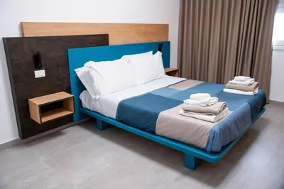 a bedroom with a blue bed with towels on it at Villa Luxury Eden di Sofia in Partinico