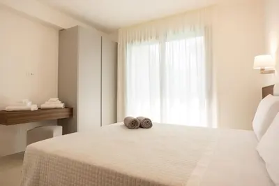 a white bedroom with two towels sitting on a bed at Luxury Jacuzzi Villa Nettuno in Palermo