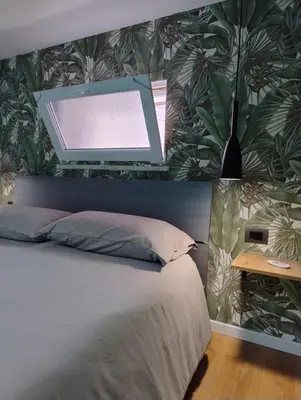 a bedroom with a bed with a large leaf wallpaper at L'angolo dei sogni in Palermo