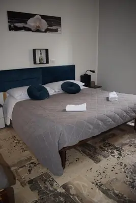 a bedroom with a large bed with blue pillows at Goethe's Sicily trip - Palermo in Palermo