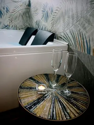 a white piano with two wine glasses on a table at Kalos suite in Palermo