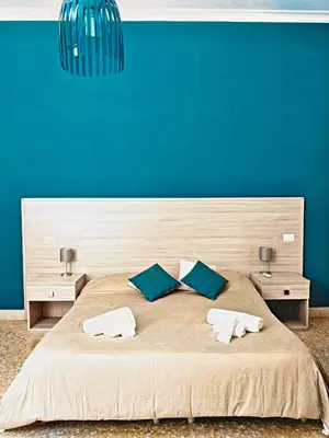a bedroom with a large bed with a blue wall at Il Quadrifoglio Room& Suite in Palermo