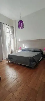 a bedroom with a bed and a purple pendant at Il Quadrifoglio Room& Suite in Palermo