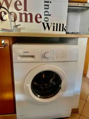 a white washing machine sitting under a counter at Fra centro & mare in Palermo