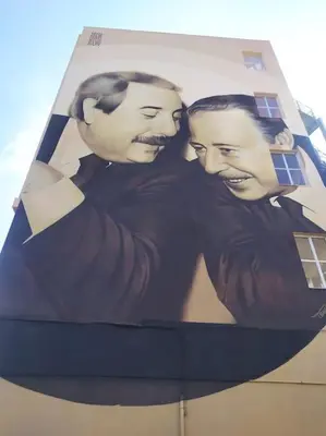 a poster of two men on the side of a building at Fra centro & mare in Palermo