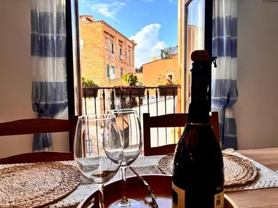 a bottle of wine sitting on a table with two glasses at Casa Cassarelli in Centro in Palermo