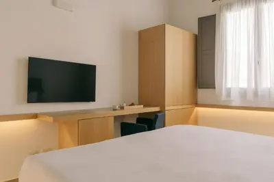 a room with a bed and a flat screen tv at Spasimo Hôtellerie in Palermo