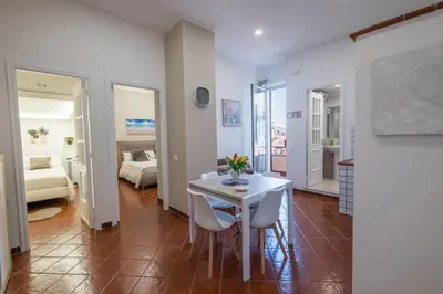a dining room with a white table and chairs at MEC apartment in Palermo
