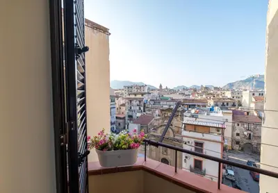 a window with a pot of flowers on a balcony at MEC apartment in Palermo