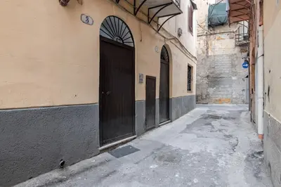 an alley with two doors on the side of a building at GuestHost - Mezzojuso Central Apartment near Via Roma in Palermo