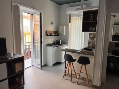a kitchen with a counter and stools in a room at Cantù Home in Misilmeri
