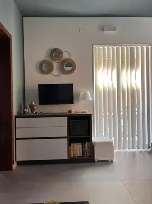 a living room with a television and a large window at Cantù Home in Misilmeri