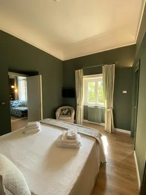 a bedroom with a large white bed and a window at Green Luxury Apartment in Palermo