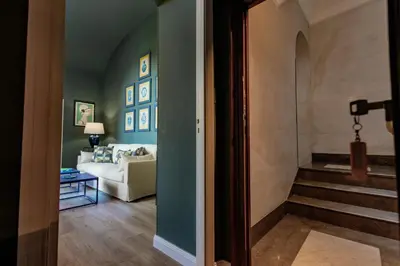 a hallway with a living room with a couch and stairs at Green Luxury Apartment in Palermo