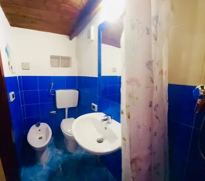 a blue and white bathroom with a sink and a toilet at Accasetta in Palermo