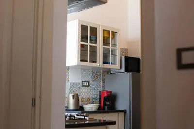a kitchen with white cabinets and a refrigerator at Vanda's Terrace in Palermo