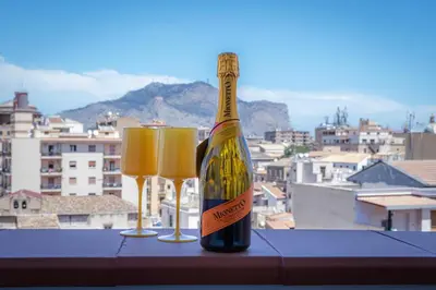 a bottle of champagne and two glasses on a table at Vanda's Terrace in Palermo