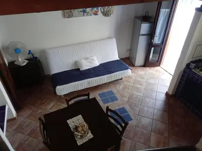 a room with a bed and a table and chairs at Rustico San Leonardo in Cinisi