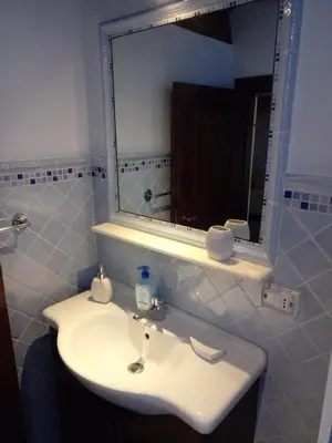 a bathroom with a white sink and a mirror at Rustico San Leonardo in Cinisi