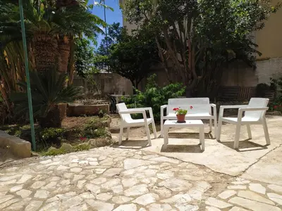 a group of chairs and tables on a patio at La Rugiada-con giardino e parcheggio moto privato in Alcamo