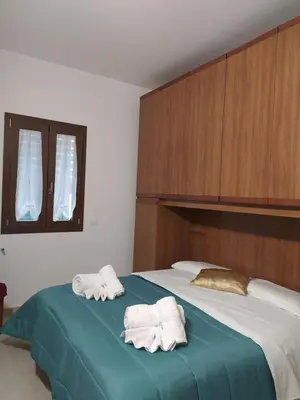 a bedroom with two towels on a bed at La Rugiada-con giardino e parcheggio moto privato in Alcamo