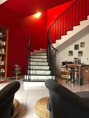 a living room with red walls and a staircase at El Nur Bed & Breakfast in San Vito lo Capo