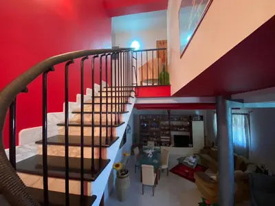 a staircase in a living room with a red wall at El Nur Bed & Breakfast in San Vito lo Capo