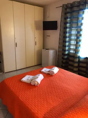 a bedroom with two towels on a orange bed at El Nur Bed & Breakfast in San Vito lo Capo