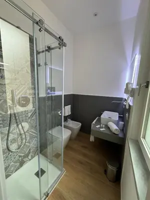 a bathroom with a glass shower and a toilet at B&B Central Station in Palermo
