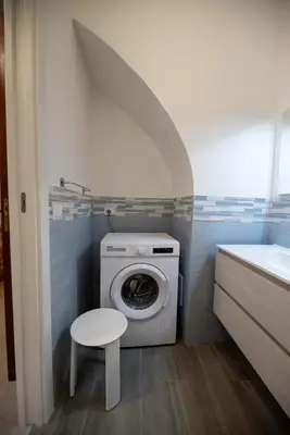a small bathroom with a washing machine and a stool at Le 4 Stagioni-nelcuorediCorleone in Corleone