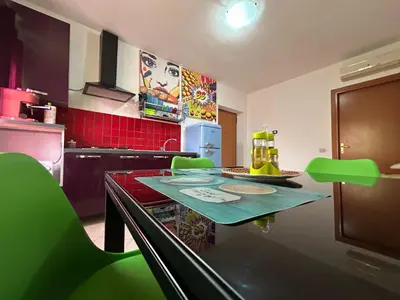 a kitchen with a green table and green chairs at Aurora house in Palermo