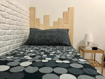 a bedroom with a black and white bed with a brick wall at Casa Vacanze Kristel in Balestrate