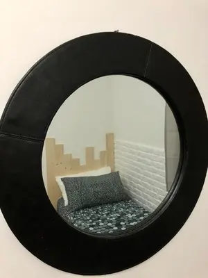 a mirror on a wall with a bed in front of it at Casa Vacanze Kristel in Balestrate