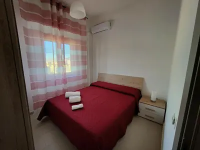a bedroom with a red bed with two towels on it at PaMa House comfort e relax a due passi dal centro in Palermo