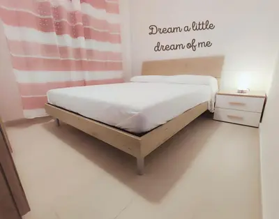 a bed in a bedroom with a sign that says dream a little dream of me at PaMa House comfort e relax a due passi dal centro in Palermo