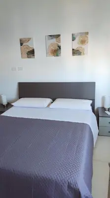 a bed in a bedroom with two pictures on the wall at PaMa House comfort e relax a due passi dal centro in Palermo