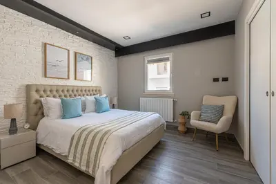 a bedroom with a large bed and a chair at La Dolce Vista - Magaggiari in Terrasini