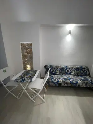a room with a bed and a table and chairs at La Maiolica 59 in Terrasini