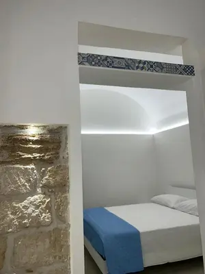 a bedroom with a bed and a stone wall at La Maiolica 59 in Terrasini
