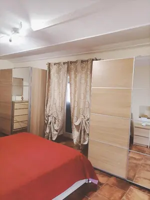 a bedroom with a red bed and some curtains at La casa del cocchiere in Palermo