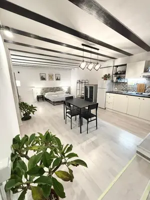 a living room with a table and a kitchen at Casa Pipa in Palermo