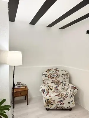a chair in a room with a lamp and a table at Casa Pipa in Palermo