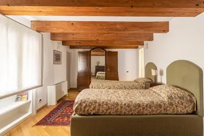 two beds in a room with wooden ceilings at Palazzo Mazzarino in Palermo