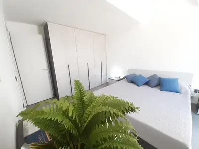 a bedroom with a bed with blue pillows and a plant at Campofelice Holidays West Villa in Campofelice di Roccella